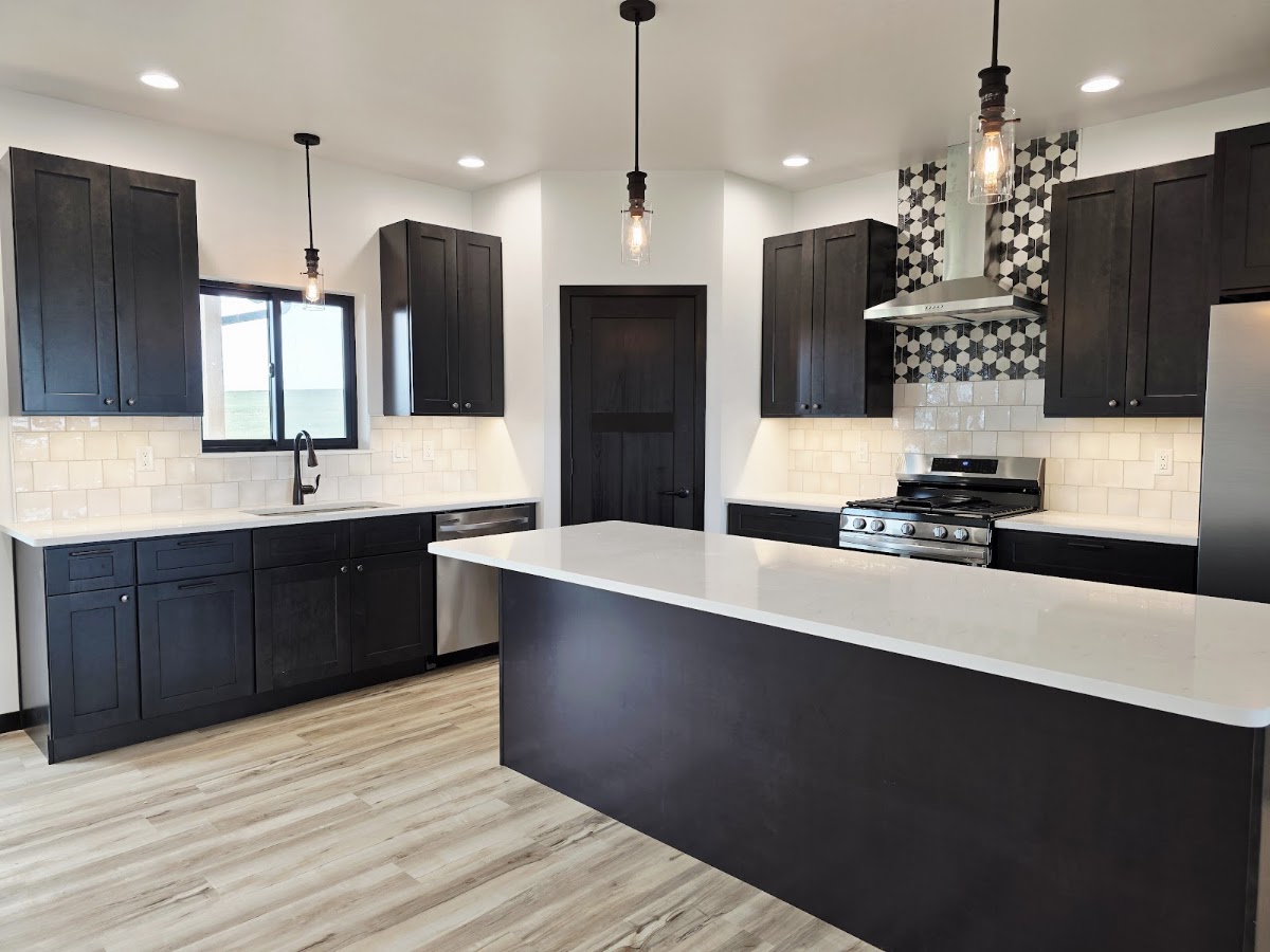Kitchen with black cabinets, island and patterned backsplash
