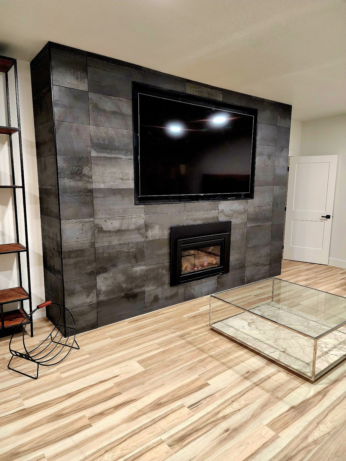 Floor-to-ceiling tiled fireplace and TV wall